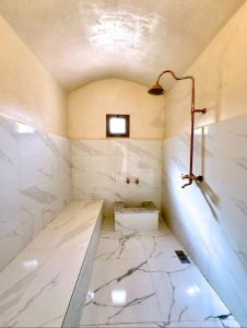 une salle de bain avec un sol en marbre blanc et une lampe dans l'établissement Villa d eden , Private Pool and Hammam, à Azib Oulad Lâdem