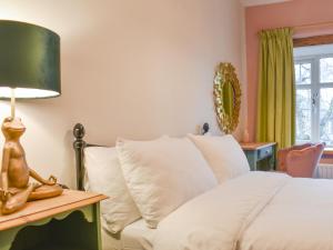 a bedroom with a white bed and a table with a lamp at Mirfield in Newbiggin