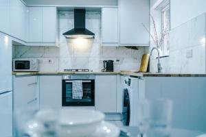 a white kitchen with white cabinets and a stove at NEW! Detached House, Driveway, Perfect for Contractors in Huddersfield