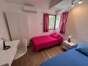 a bedroom with two beds and a red bed at Sunny Villa Maspalomas in Maspalomas +20 photos