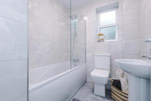a white bathroom with a toilet and a sink at NEW! Detached House, Driveway, Perfect for Contractors in Huddersfield +13 photos