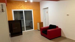 a living room with a red chair and a mirror at Smart Stay in Craiova +1 photo