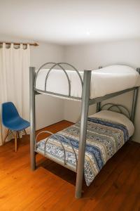 Litera en habitación con silla azul en San Telmo Blue house, en Buenos Aires