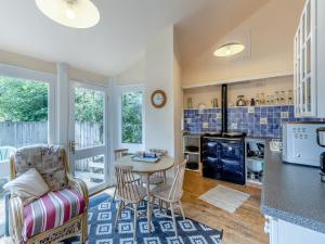a kitchen and living room with a table and chairs at Primula House in Sticklepath