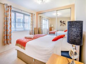 a bedroom with a large bed and a mirror at Marina View Apartment in Swansea