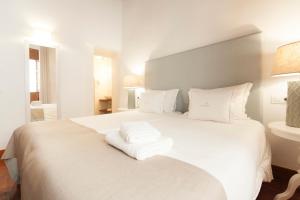 a white bed with two towels on top of it at Apartamentos Casa del Aceite in Córdoba