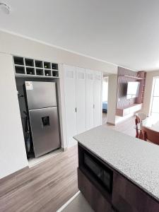 a kitchen with a refrigerator and a counter top at La Foret in Lima