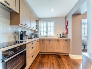a kitchen with wooden cabinets and a wooden floor at Royal Aberdeen - Ukc6917 in Turnberry