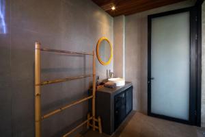 a bathroom with a sink and a mirror on the wall at Umah Adenium Ubud in Tegalalang +96 photos