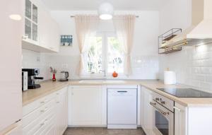 a white kitchen with white cabinets and a window at Lovely Home In Sinj in Rožani