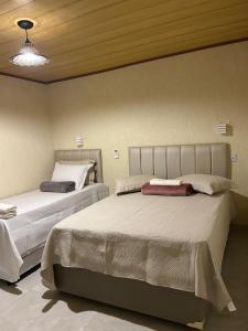 a bedroom with two beds and a ceiling at Suite Tarituba 2 in Angra dos Reis