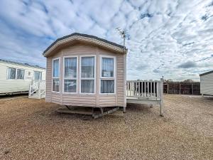 Una casa pequeña con una ventana grande en un patio. en 6 Berth Caravan Nearby Hunstanton Beach Front In Norfolk Ref 13019L, en Hunstanton