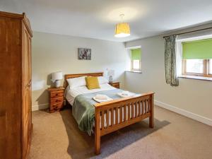 a bedroom with a bed and a table and a window at The Dairy -Uk50616 in Cynwyd