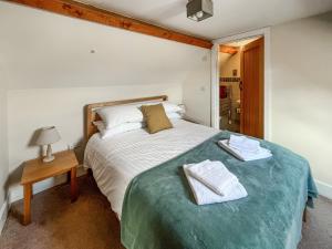 a bedroom with a bed with two towels on it at The Dairy -Uk50616 in Cynwyd +17 photos