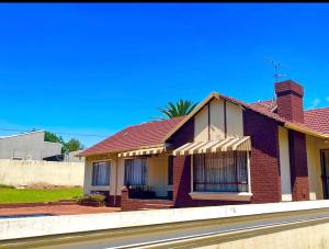 a red brick house on the side of a street at Inconova fly in Kempton Park