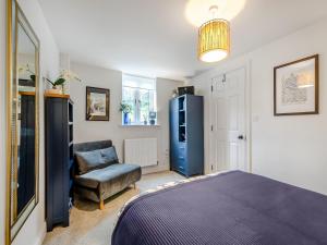 una camera da letto con frigorifero blu e sedia di The Colleys a Lechlade