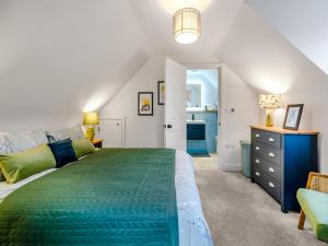 una camera con letto verde e comò blu di The Colleys a Lechlade