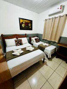 a bedroom with two beds and a air conditioner at Casa Flor do ipê Homes in Nobres