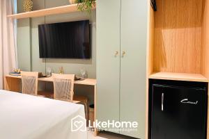 a room with a bed and a table and a tv at Setai Aquamaris - LikeHome Hospedagens in Tambaú