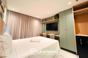 a hotel room with a bed and a tv at Setai Aquamaris - LikeHome Hospedagens in Tambaú