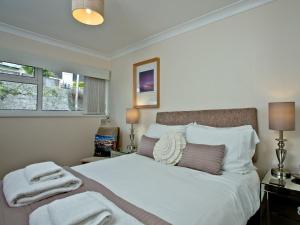 a bedroom with a white bed with towels on it at 3 Linden Court in Brixham +6 photos