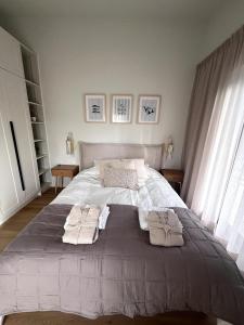 a bedroom with a large bed with towels on it at Nordic Zen 2BR Beach House - Bali-Inspired Calm in Skulte