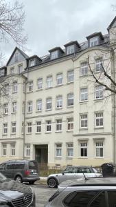 a large building with cars parked in front of it at Appartement Chemnitz-Kaßberg in Chemnitz