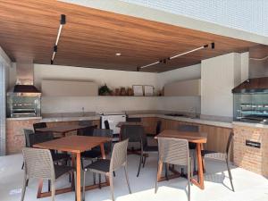 a kitchen with wooden tables and chairs in a kitchen at Studio Gardenia Mobiliado - Batista Campos in Belém