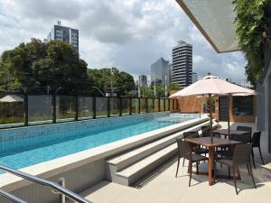 a swimming pool with a table and chairs on a building at Studio Gardenia Mobiliado - Batista Campos in Belém