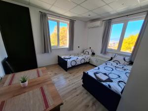 une chambre avec deux lits, une table et des fenêtres dans l'établissement Bubolina House, à Sapareva Banya