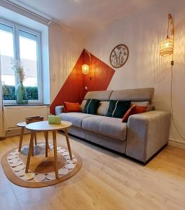 a living room with a couch and a table at Le Cocon d'Anna - Le studio in Dole