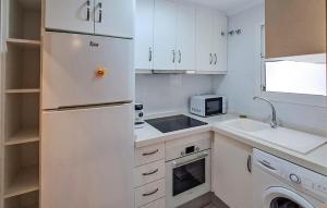 cocina blanca con nevera y fregadero en Cozy Apartment In Torrevieja With Wifi, en Torrevieja