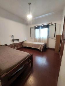 a bedroom with two beds and a window at Casa Centrica Mina Clavero in Mina Clavero