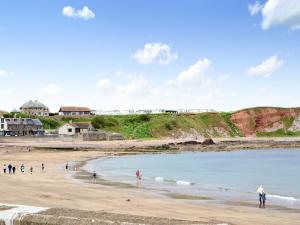 eine Gruppe von Menschen, die am Strand stehen in der Unterkunft Diggers Cottage in Oxton