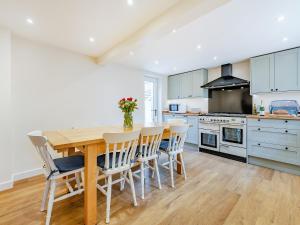 a kitchen with a wooden table and chairs at Bourne Farm Cottage in Blandford Forum