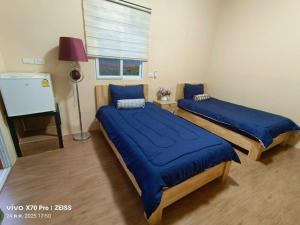 2 Betten in einem Zimmer mit blauer Bettwäsche in der Unterkunft Da-Kanda Boutique in Klong Muang Beach + 126 Fotos