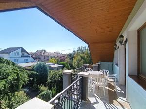 a patio with a table and chairs on a balcony at Édenkert Apartman in Keszthely