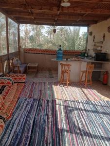 锡瓦Siwa Spot的客厅设有厨房和大地毯。