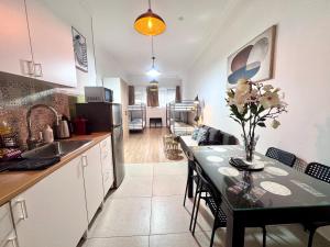 Una cocina con una mesa con un jarrón de flores encima. en Sint-Jans Appartments, en Amberes
