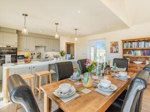 a kitchen and dining room with a wooden table and chairs at Lizzie's Cottage in Skendleby