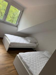 Un dormitorio abuhardillado con dos camas y una ventana. en Appartement - Nähe Flughafen, en Langenpreising