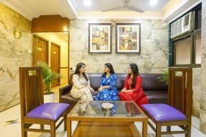 ムンバイにあるFabHotel Cruz Royale - Nr- Bandra Westのリビングのソファに座る三人の女性