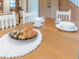 a table with a plate of croissants and bread on it at Rectory Cottage in Dibden