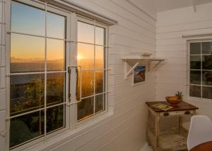 Zimmer mit einem Fenster und Blick auf den Sonnenuntergang in der Unterkunft Oceanside Cottage in Rocklands + 4 Fotos
