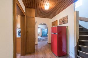 einen roten Kühlschrank in einem Zimmer mit einer Treppe in der Unterkunft Apartment Anny in Bruck an der Großglocknerstraße
