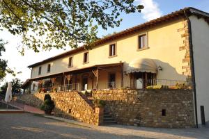 un grand bâtiment avec un mur en pierre et un bâtiment dans l'établissement La Torricella, à Poppi