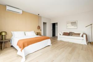 a bedroom with a large bed and a couch at Kemay Hotel Boutique in José Ignacio