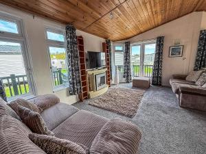 - un salon avec canapés, télévision et fenêtres dans l'établissement Modern 4 Berth Lodge With Decking At Manor Park In Hunstanton Ref 23024W, à Hunstanton