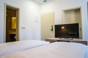 a hotel room with a television and a bed at Hotel Kapetanovina in Mostar