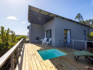 a house with a deck with a swimming pool at Cliffside Suites in Plettenberg Bay